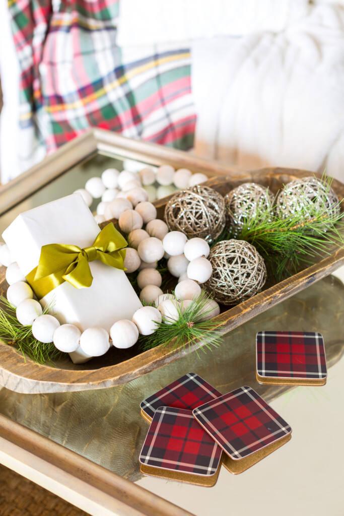 Large dough bowl on table decorated for Christmas.