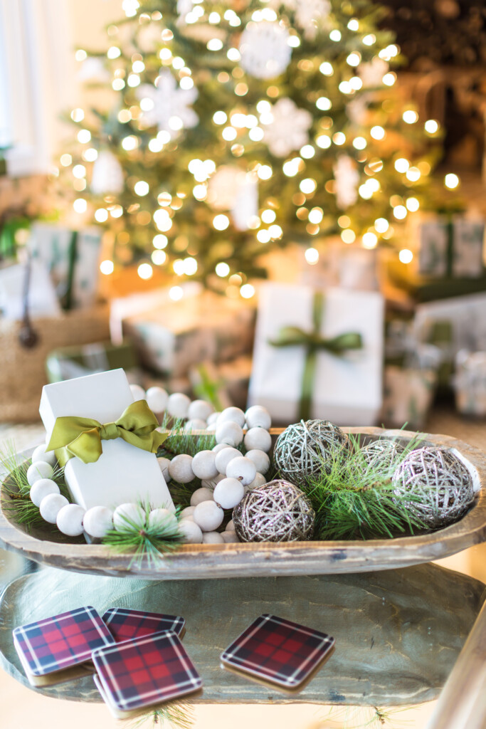 Large dough bowl on table decorated for Christmas.