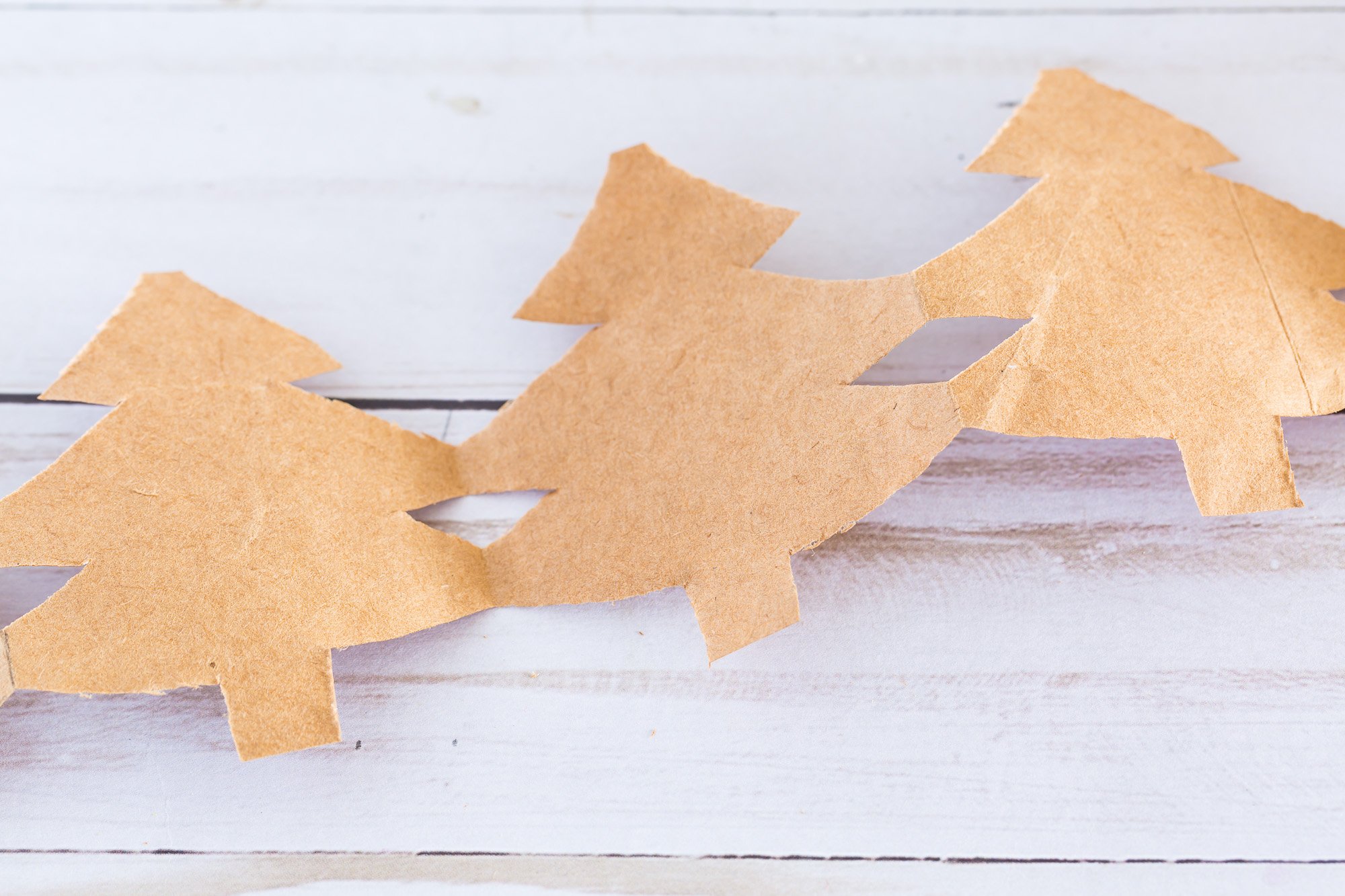 Christmas Tree paper chain made using a brown paper bag unfolded to reveal Christmas tree shaped design.