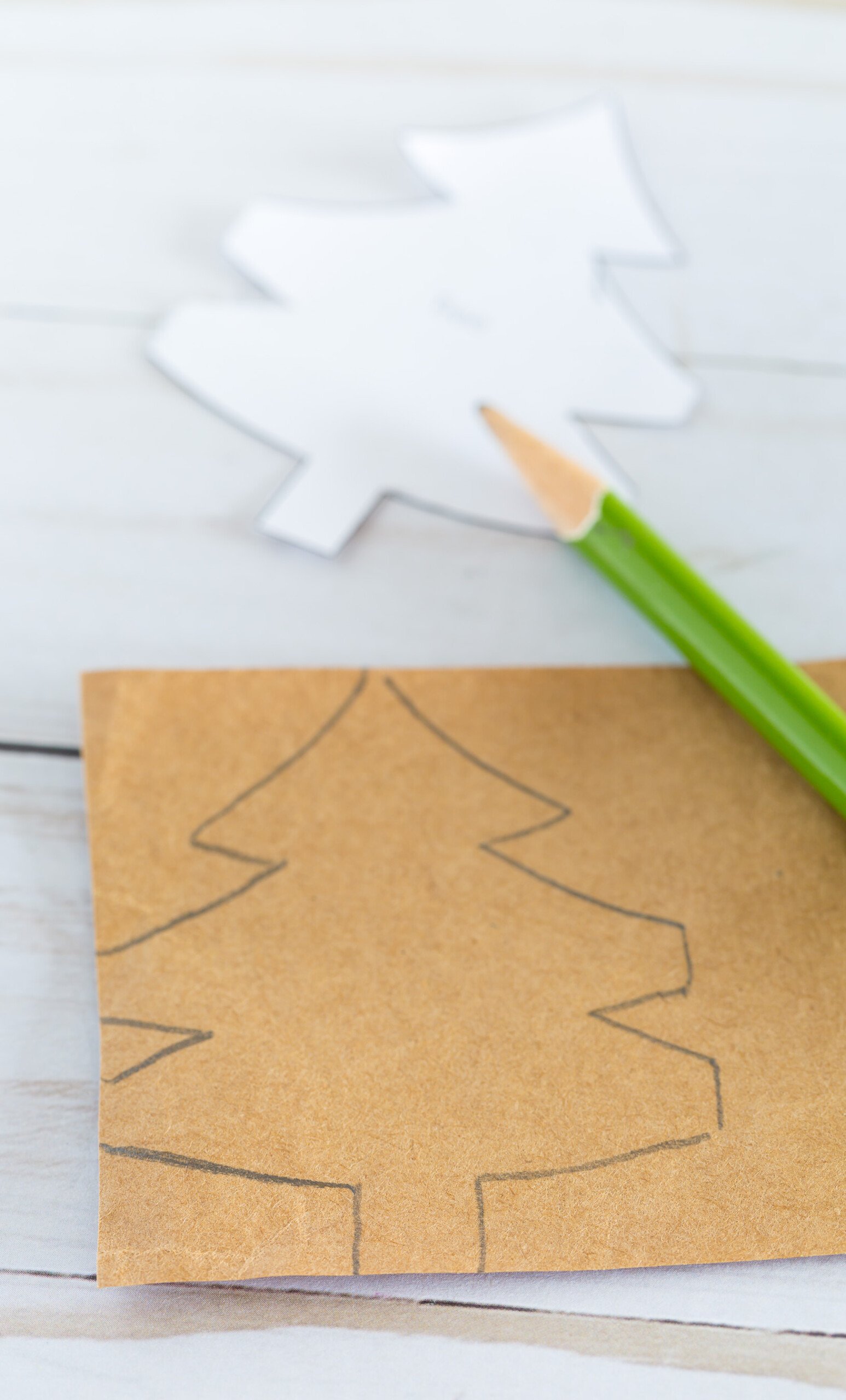 How to trace a template of a Christmas tree pattern on to a strip of paper.
