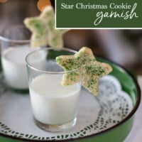 two star shaped Christmas cookies on rims of glasses filled with milk