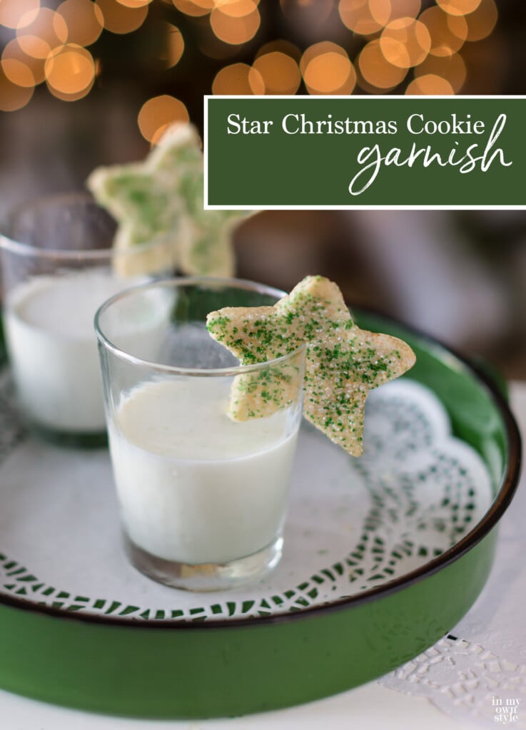 two star shaped Christmas cookies on rims of glasses filled with milk