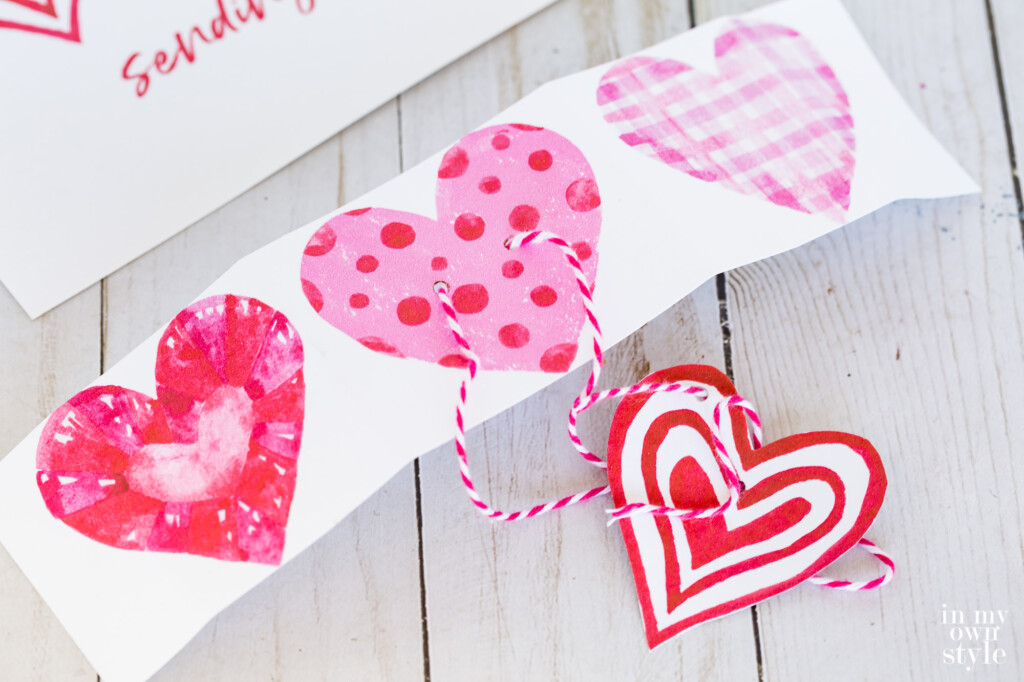 A strip cutout of 3 hearts from a free printable to use as a gift tag.