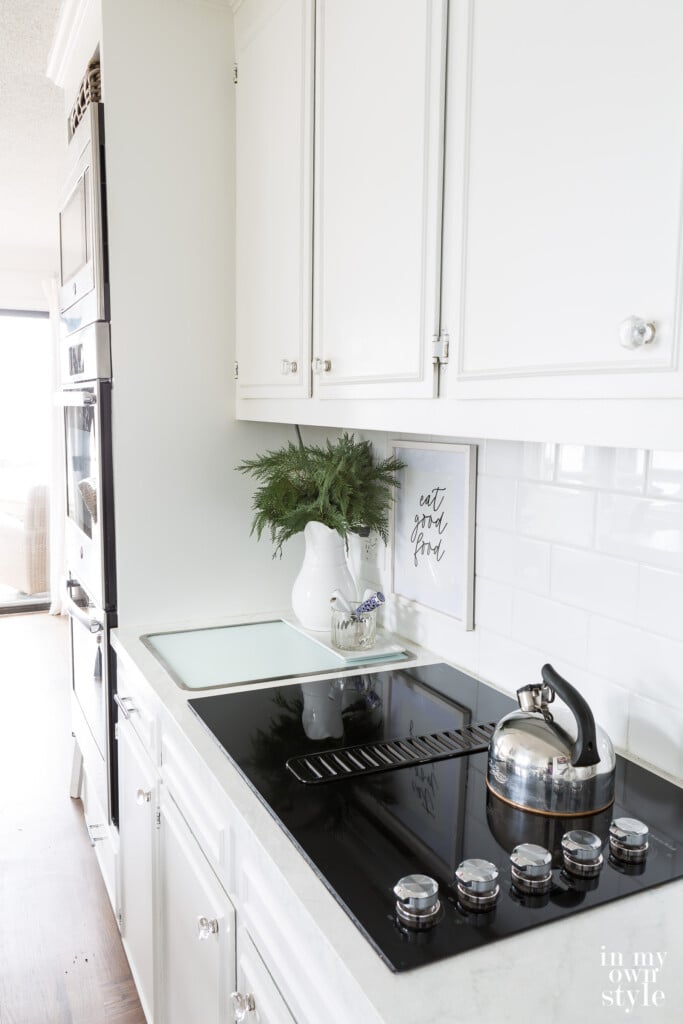 Small kitchen counter with glass cutting board in-set into counter.