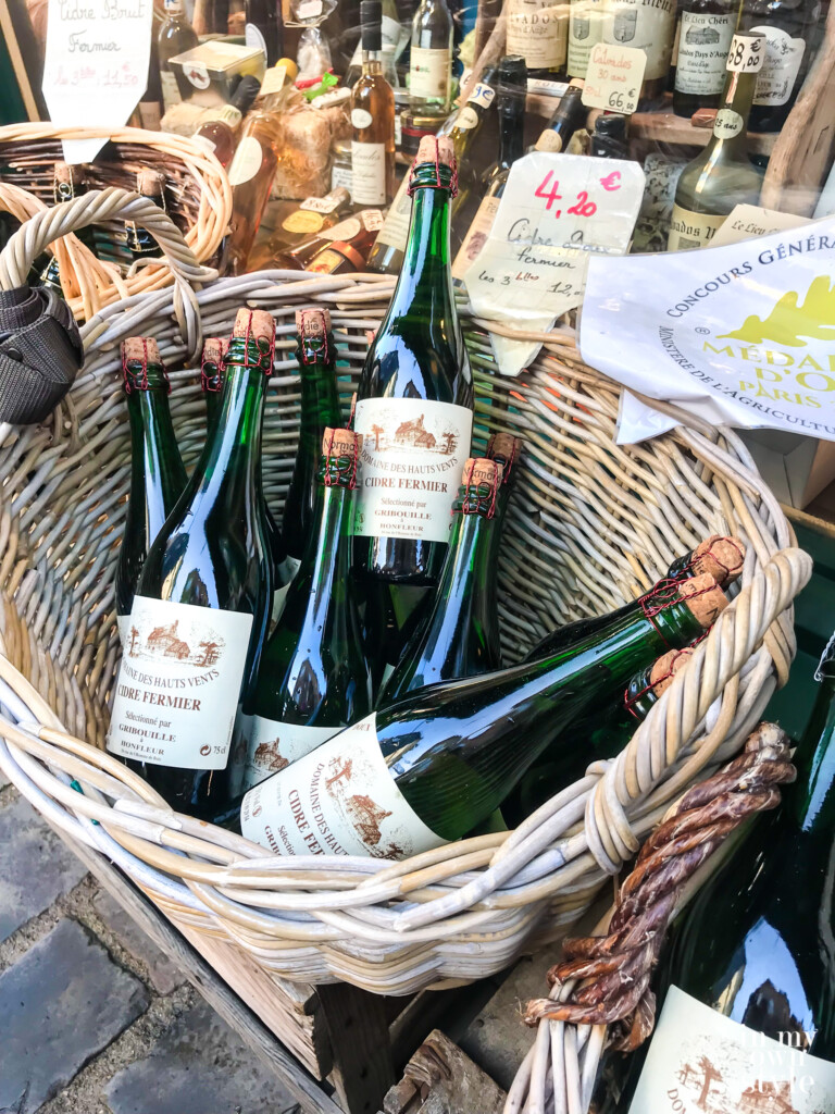 Basket filled with green bottles of French wine.