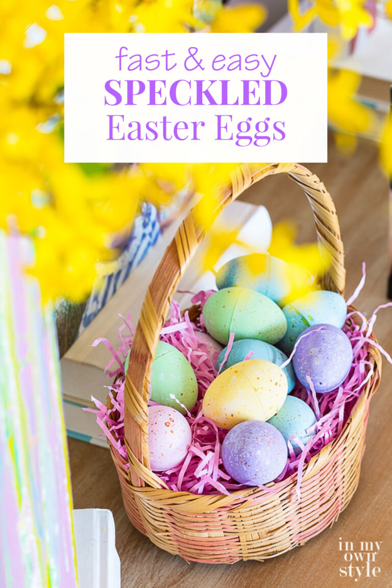 Easter basket on table with painted speckled eggs nestled inside.