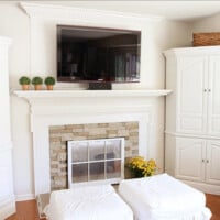 Living room with wall mounted TV over a fireplace with the hanging TV cords hidden by a DIY cover.