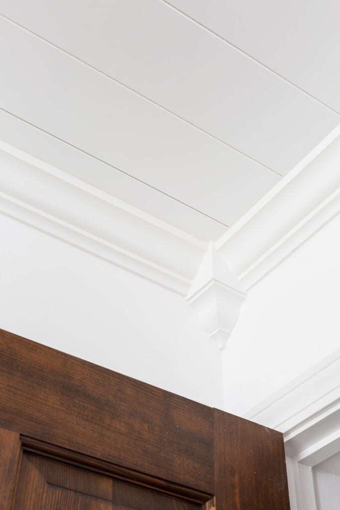 Corner of a ceiling with decorative crown molding and Armstrong WoodHaven Planks