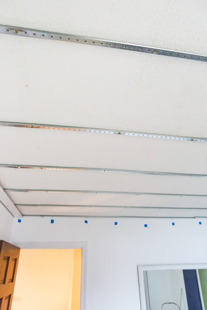 Covering a ceiling using Armstrong Easy Up tracks and clips. Once tracks are up, snap-on clips are used to attach planks. 