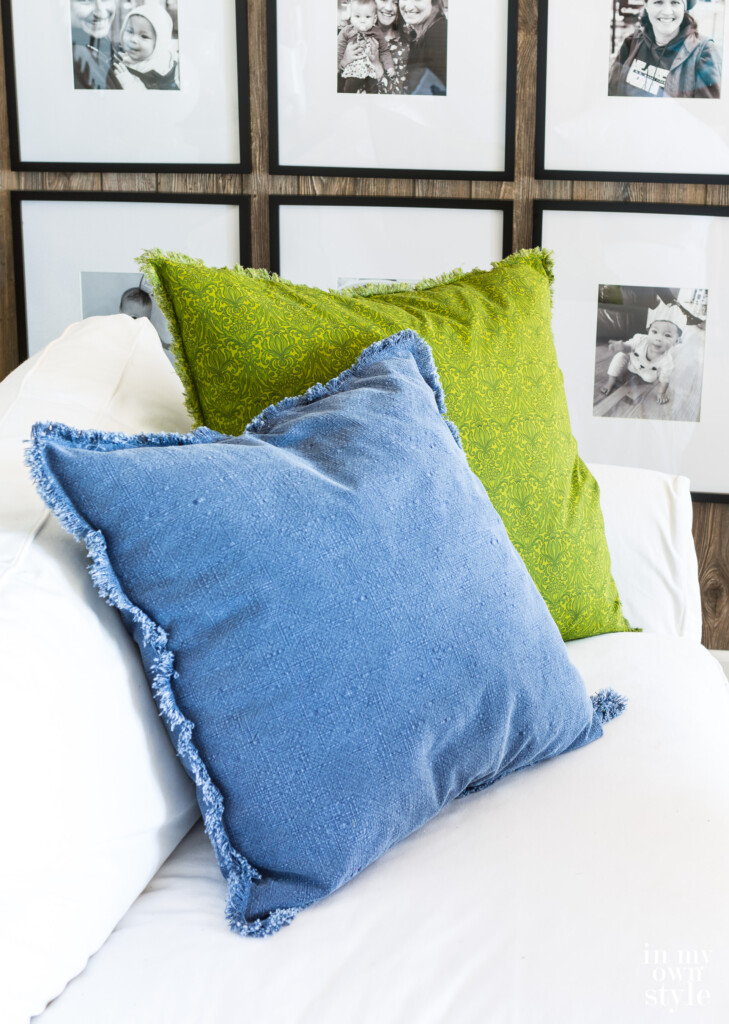 Two fringe edges pillows on a white sofa. One made in blue demin and the other in a pretty spring green fabric. Both have DIY fringe around the edges. Find out how easy this type of fringe is to make on the edge of fabric, even tightly woven fabric. 