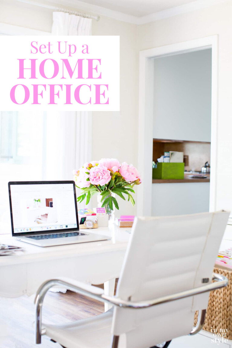 A home office with a white and pink color palette.