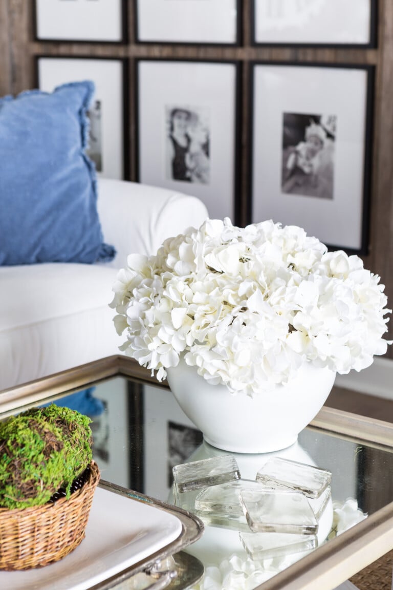 White spray painted planter filled with white hydrangeas on coffee table