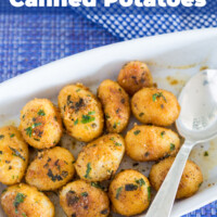 Herbed Encrusted Canned Potatoes in a white serving dishes being spooned out.