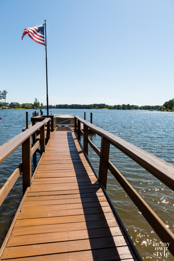 Long lake dock after getting stained, American flag blowing in the breeze.