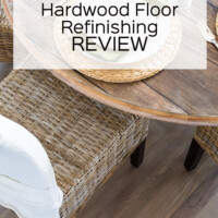 Hardwood floor refinished in kitchen in a driftwood grey color. Kubu style dining chairs around table. Text overlay says Bona Hardwood Floor Refinishing Review