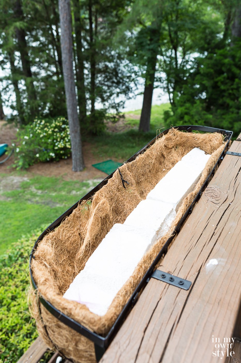 Long pieces of Styrofoam in a deck railing planter.