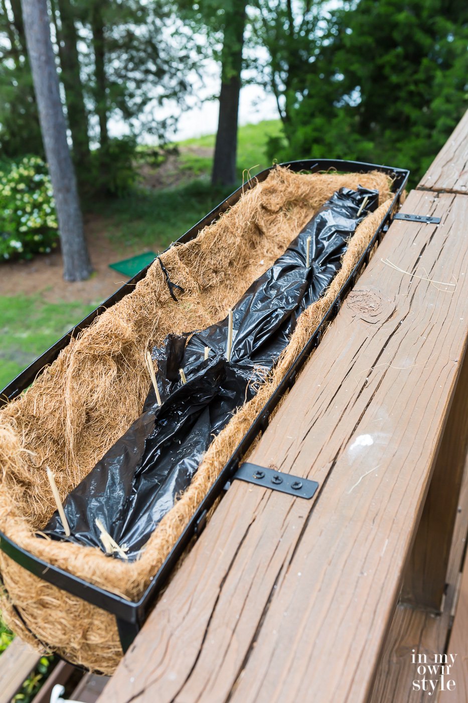 How to secure fake flowers in a window or deck railing planter box.