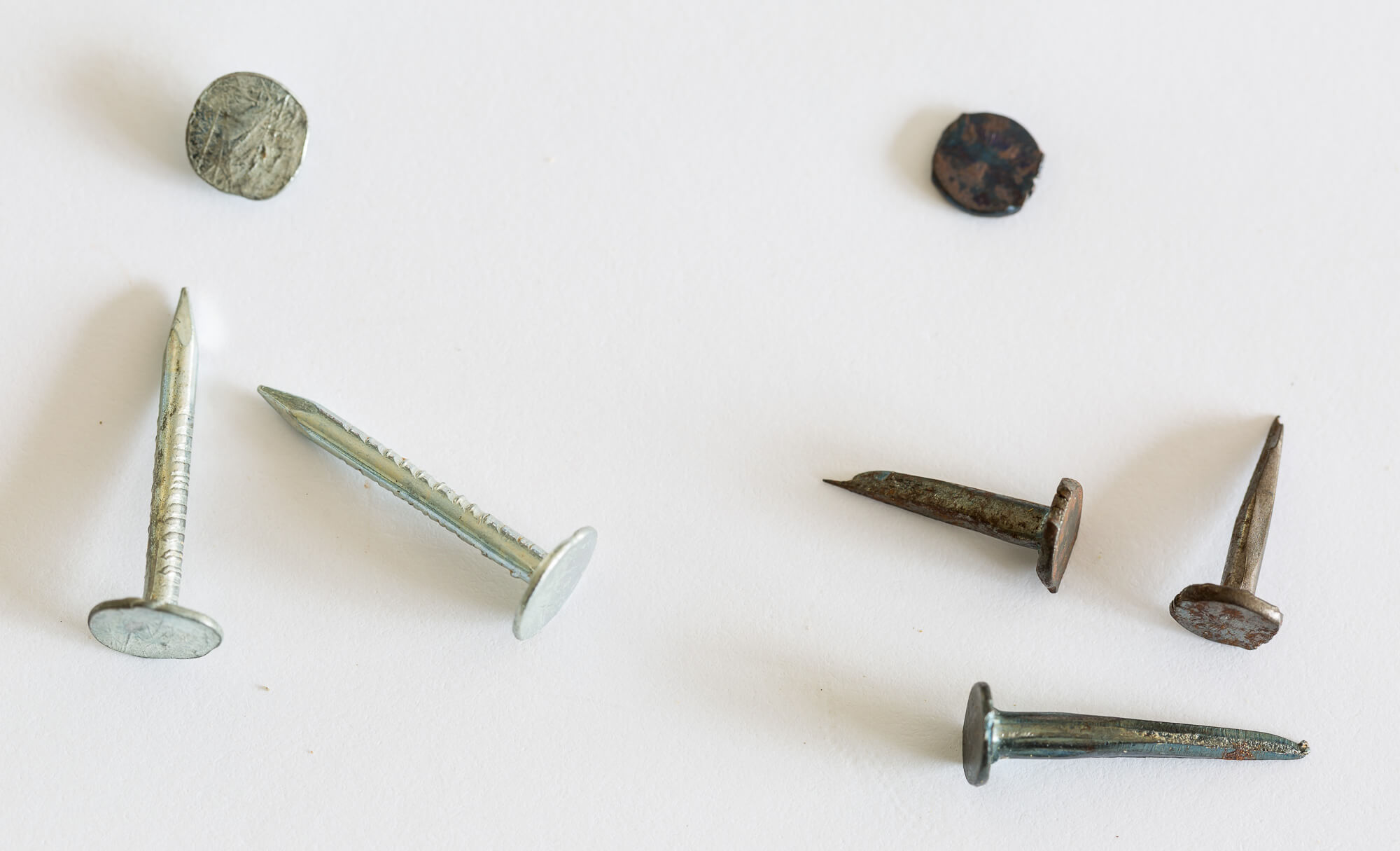 Flat head nails and carpet tacks used to construct a wood wine crate recipe card holder.