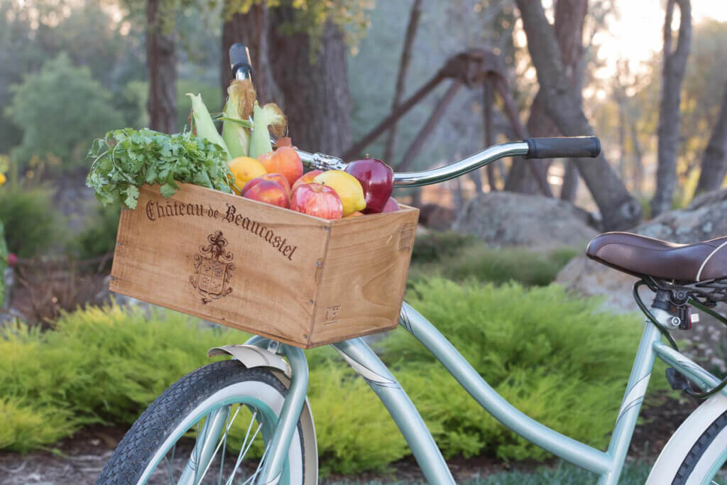 Bike with a wood wine crate made into a bike basket attached to the handlebar.