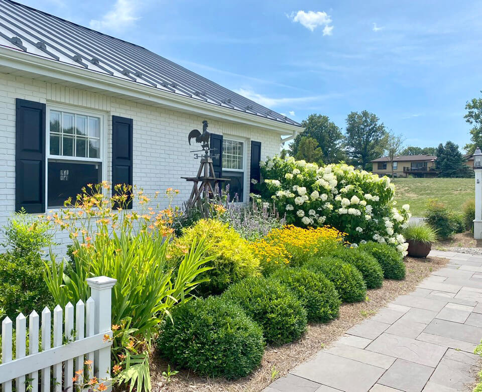 Front walkway made of slate in front of white farmhouse