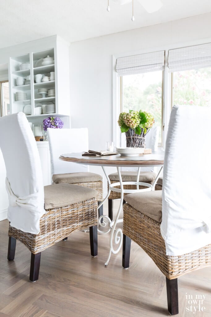Dining chair and table in kitchen showing new neutral cushion covers on chairs made from fabric from the fabric of a broken patio umbrella.
