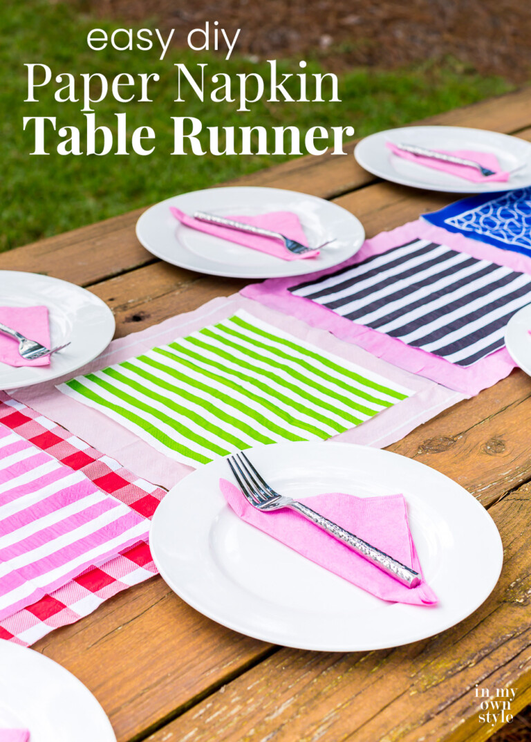 Outdoor picnic table with a colorful table runner in center made with paper napkins.