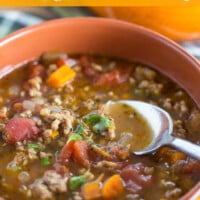 Bowl of Sausage and Lentil soup being spooned out. Text overlay says Hearty Sausage and Lentil Soup