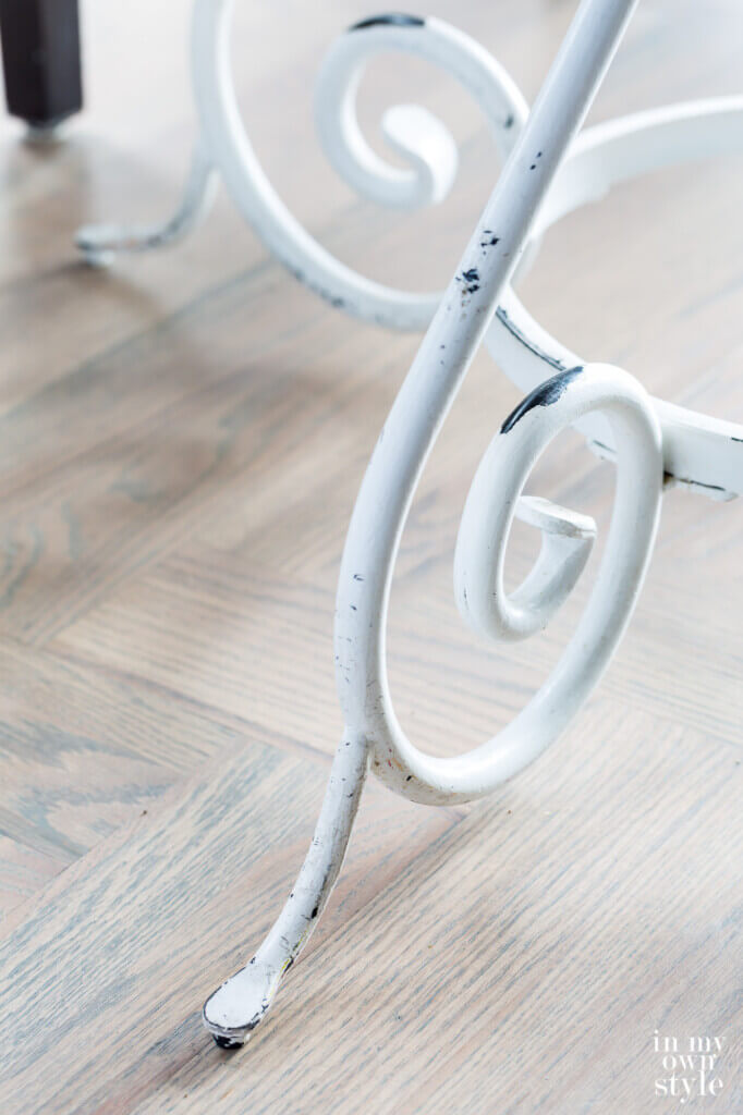 White painted metal table legs that have worn showing the black wrought iron underneath that gives the table a vintage look. Perfect for fall.
