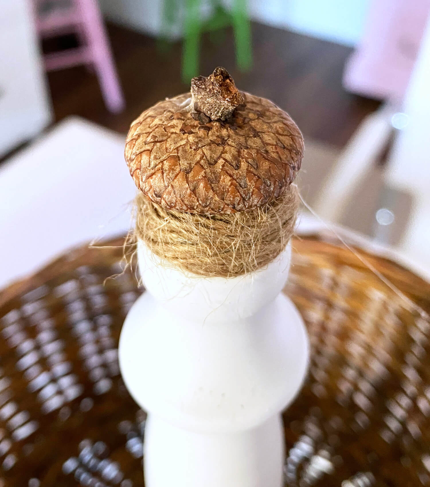 Top of real acorn found in nature made into a decorative fall finial for a 2 tiered countertop fruit basket.