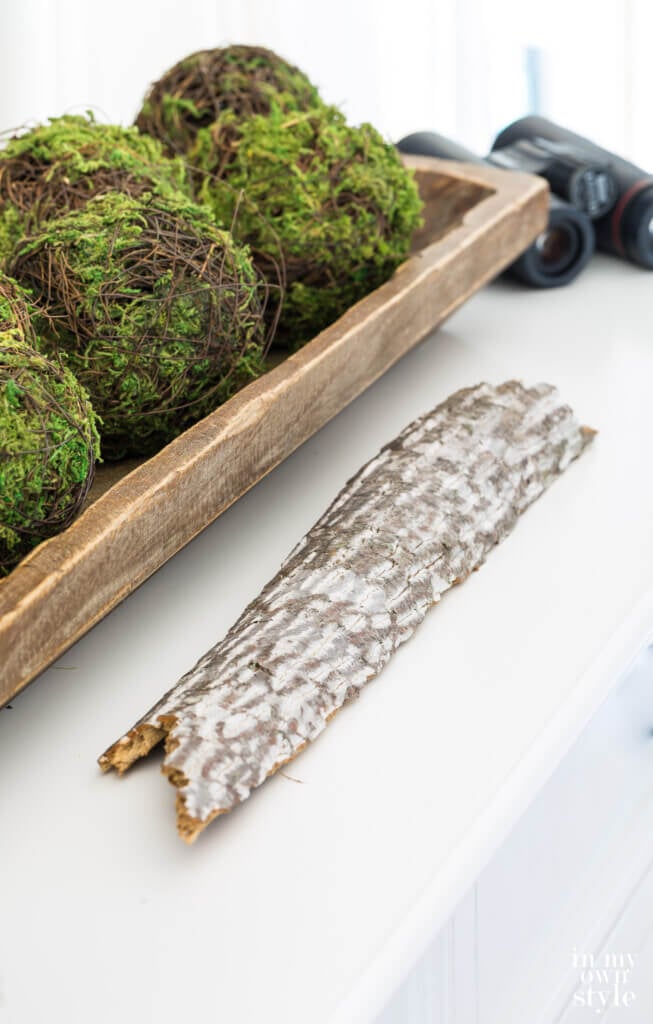 Decorating with nature for fall. Piece of bark and long dough bowl filled with moss spheres.