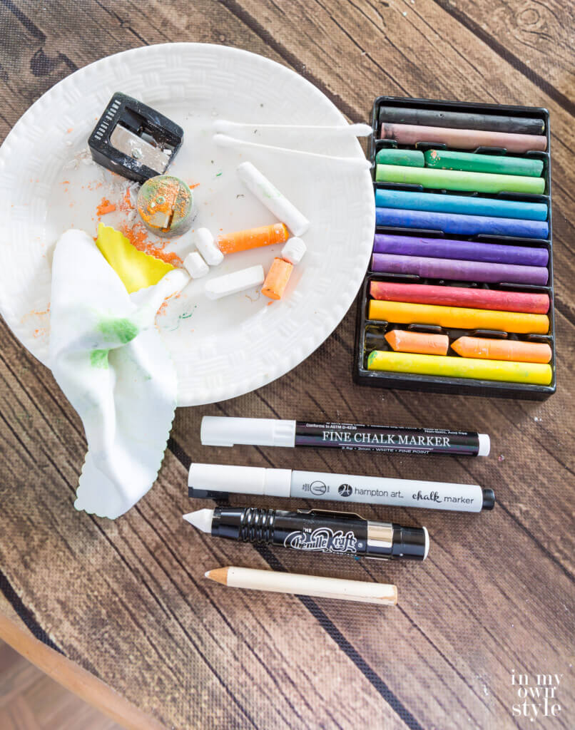 Chalkboard wall drawing supplies on table.