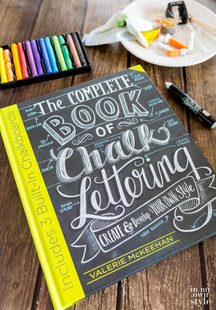 The Complete Book of Chalk Lettering by Valerie MC Keehan on a table with chalk and tools around it.