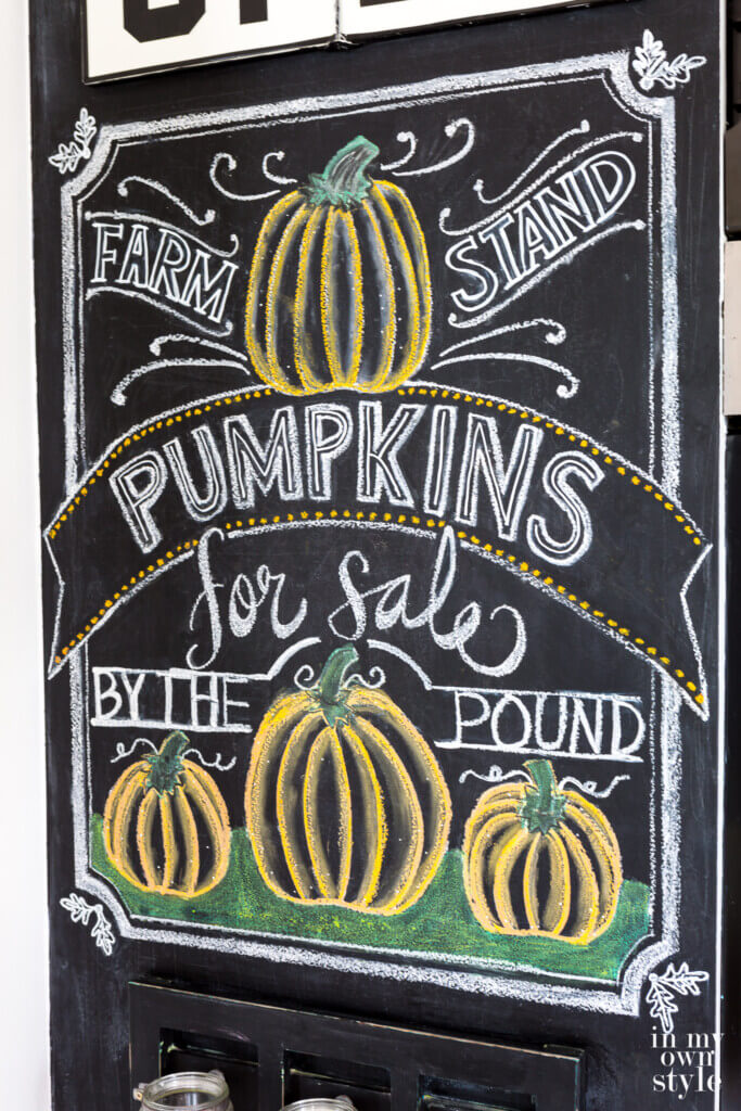 Close up angled shot of fall chalkboard art on a wall in a kitchen.