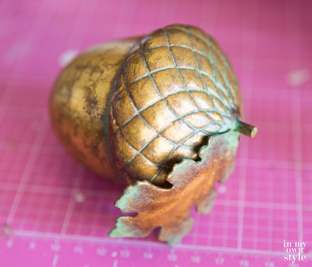 Decorative gold acorn before getting a new aged finish with paint.