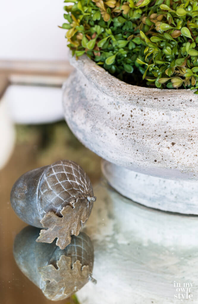 DIY concrete look finish on planter and rustic aged decorative acorn.