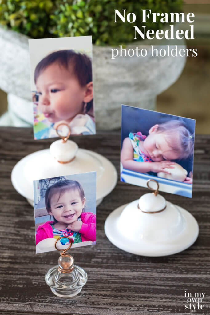 3 lid photo holders made with teapot and other lids with photos on display on a table. Text overlay says No Frame Needed photo holders.