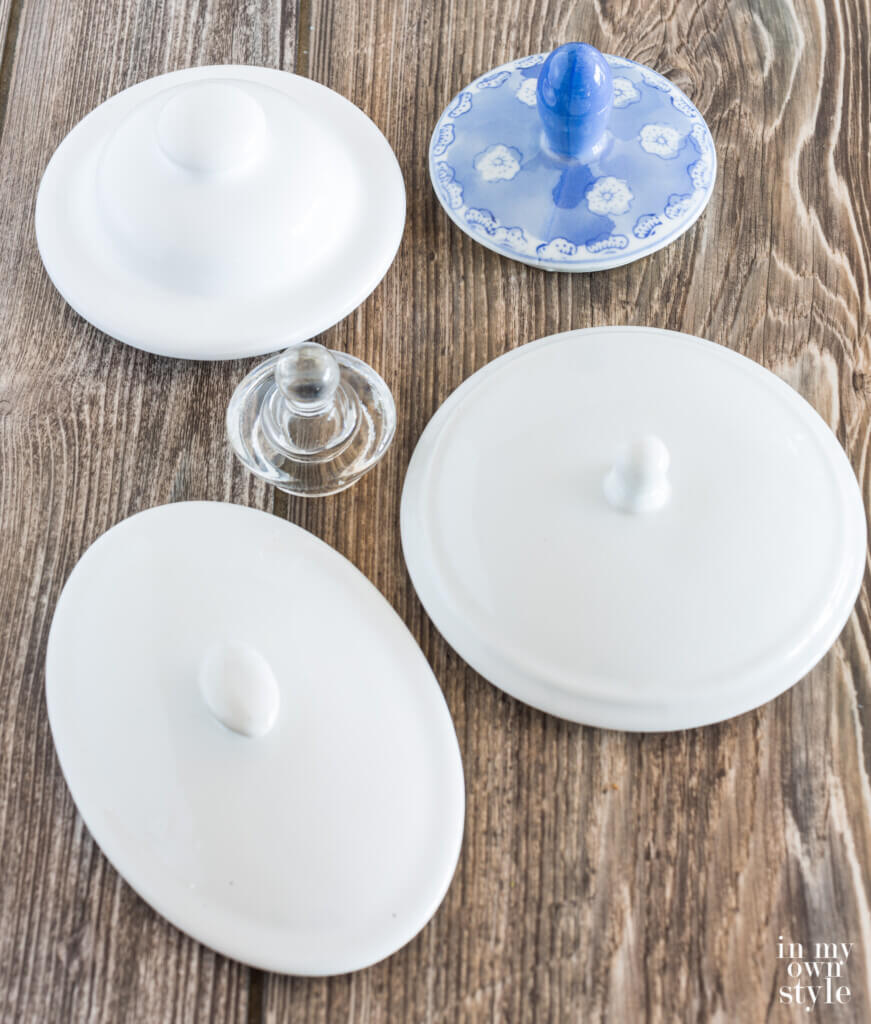 Ceramic and glass jar lids with knobs on table.