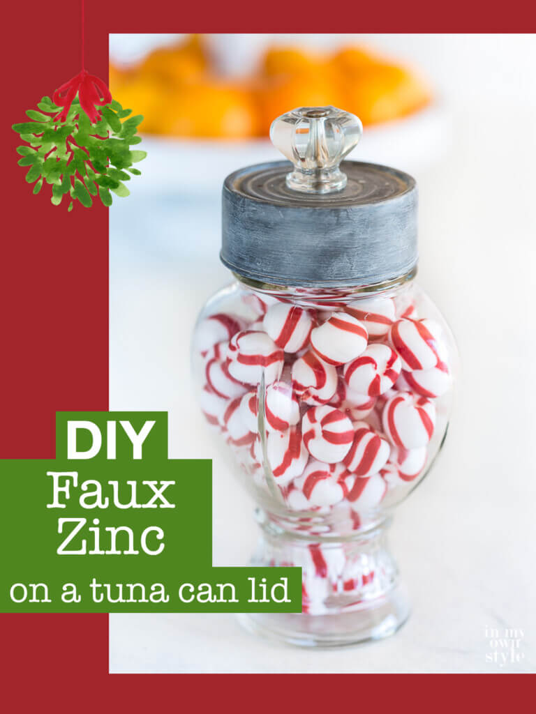 Glass canister jar with a top made using a tuna can painted with a faux Zinc finish. Text overlay says DIY Faux Zinc on a tuna can lid.