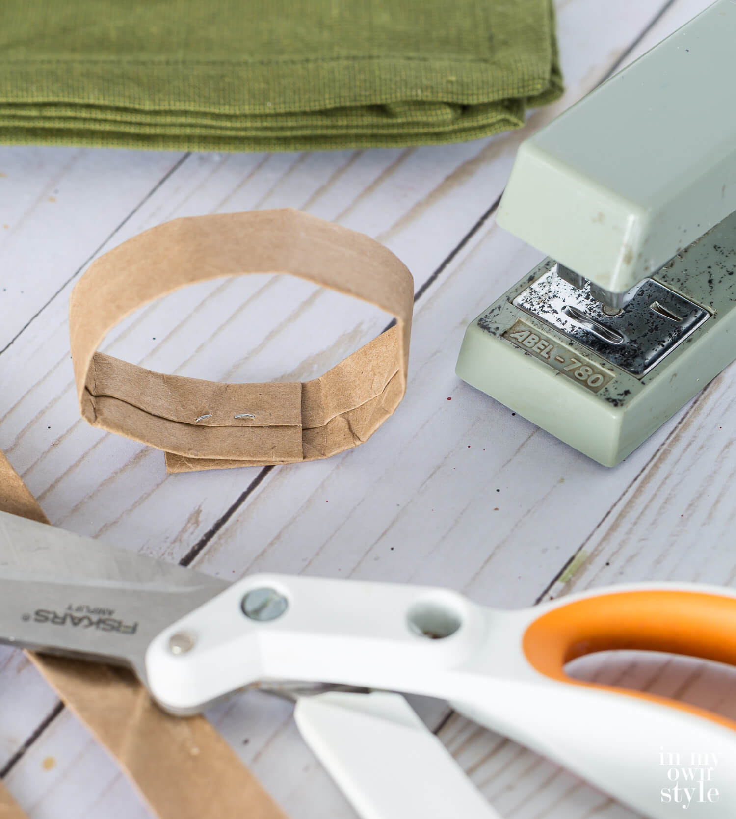 Brown paper bag handle stapled into a circle to make a napkin ring.
