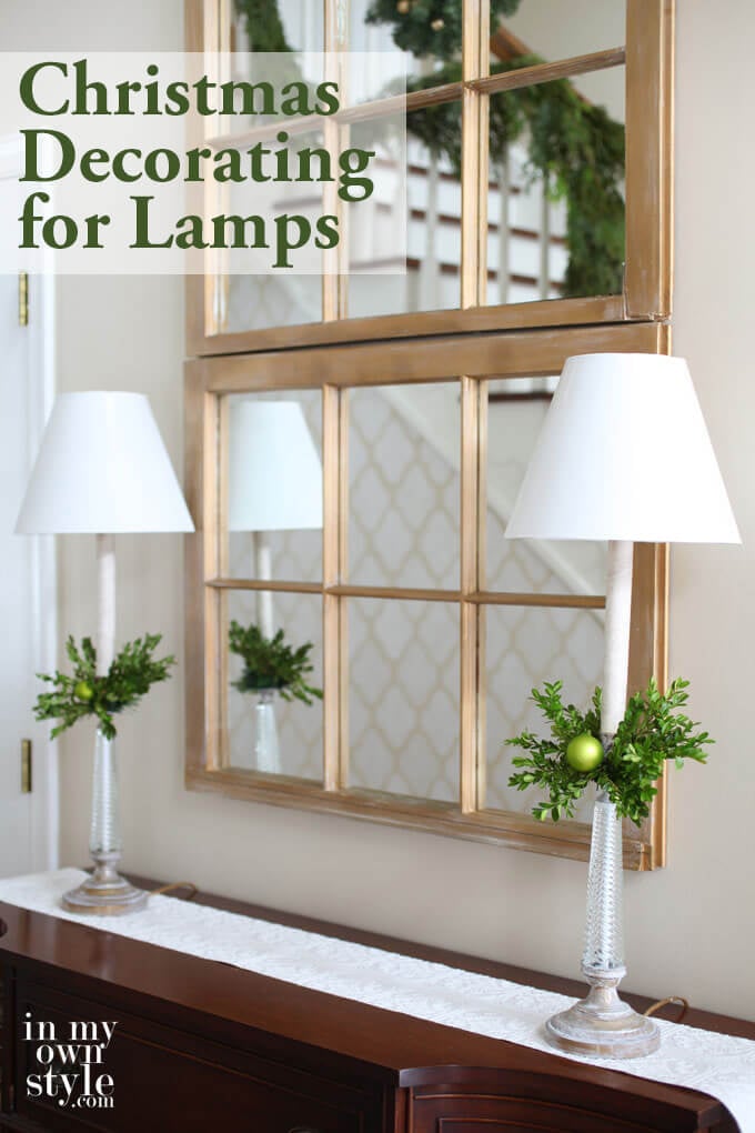Two tall buffet style lamps of sideboard in foyer. Text overlay says Christmas decorating for Lamps