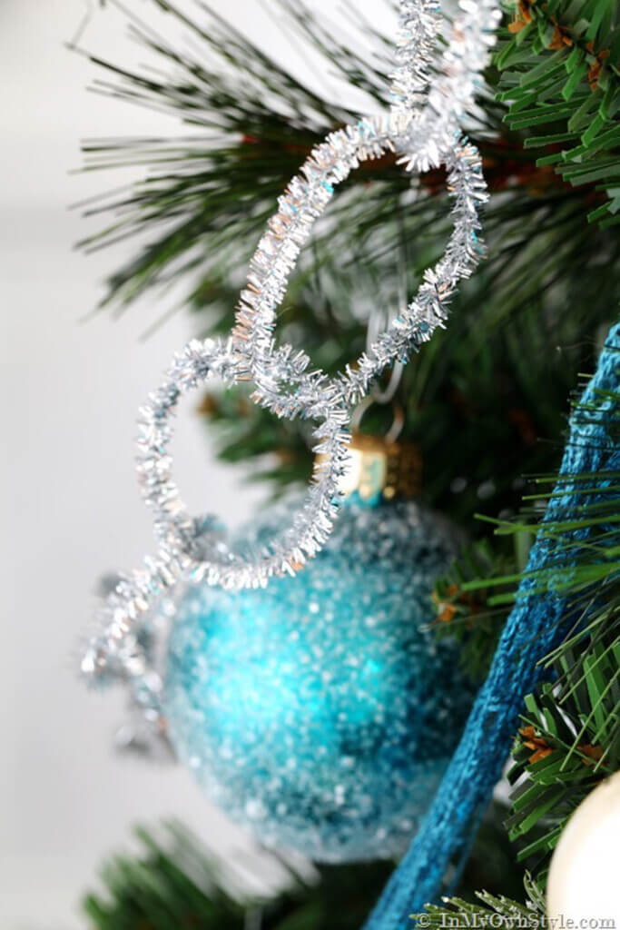 Sparkly Silver pipe cleaner garland and turquoise ornaments on Christmas tree.