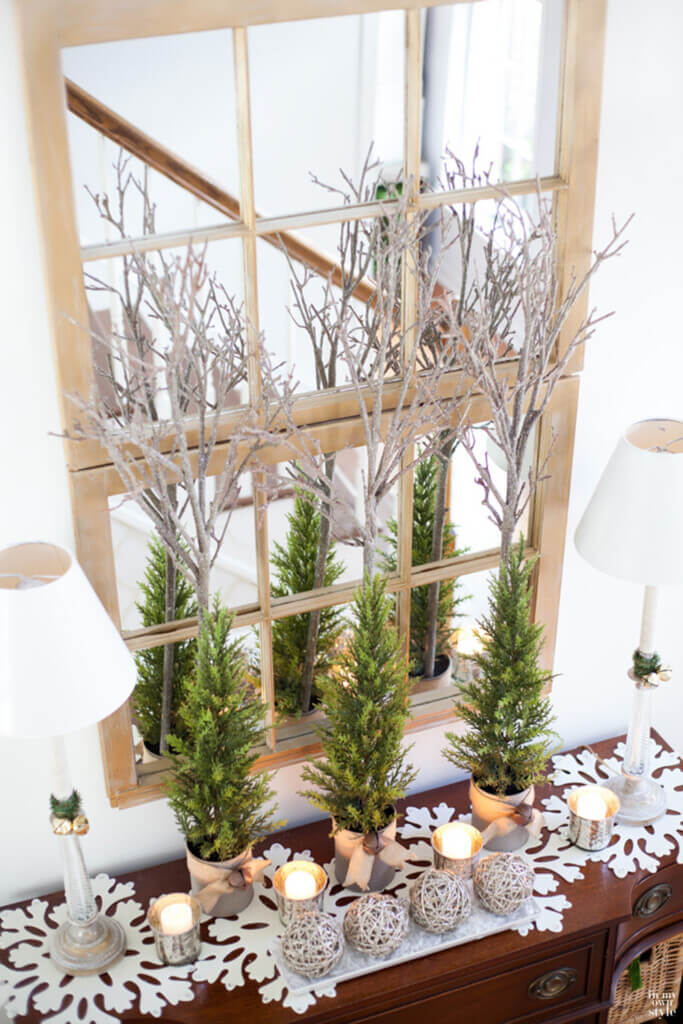 Foyer in home decorated for Christmas with silver branches, pine and felt snowflake mats.