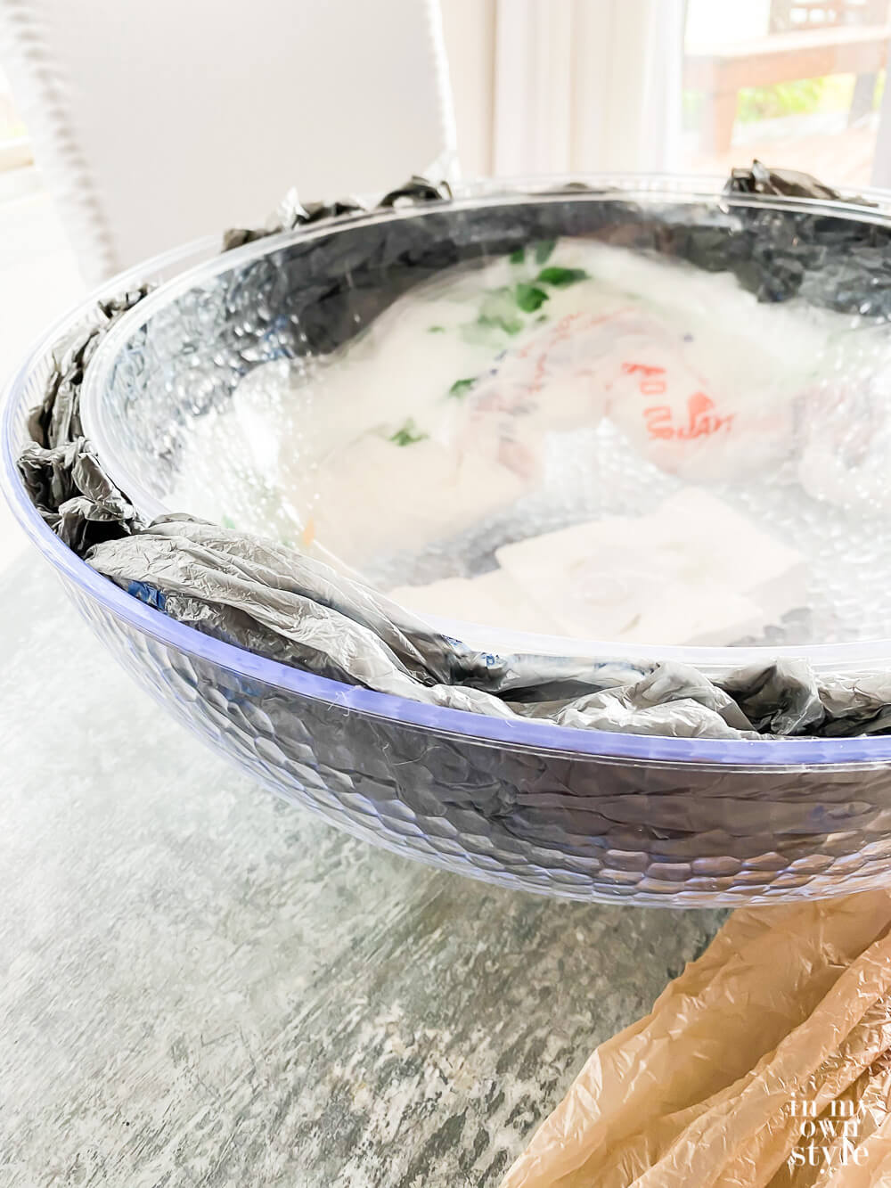 Filling the area between the bowls with plastic grocery bags.
