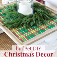 Coffee table covered with green plaid gift wrap, wreath and candle.