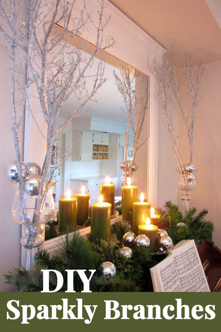DIY sparjly branches decorating the top of a piano. Candles lit around them to add a magical glow.