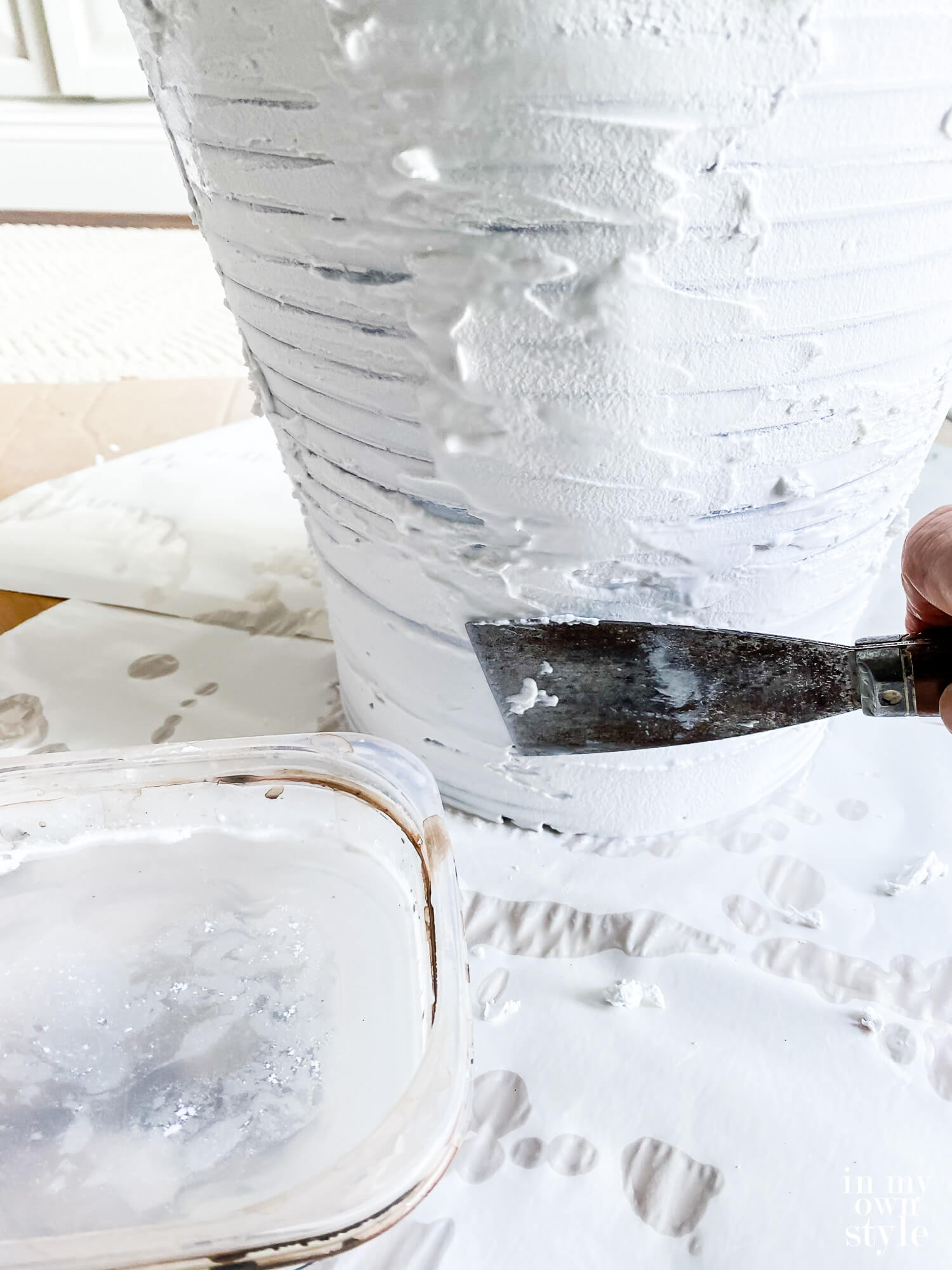 Adding a layer of Spackle to a thrift store lamp to transform it so it looks like one from Pottery Barn