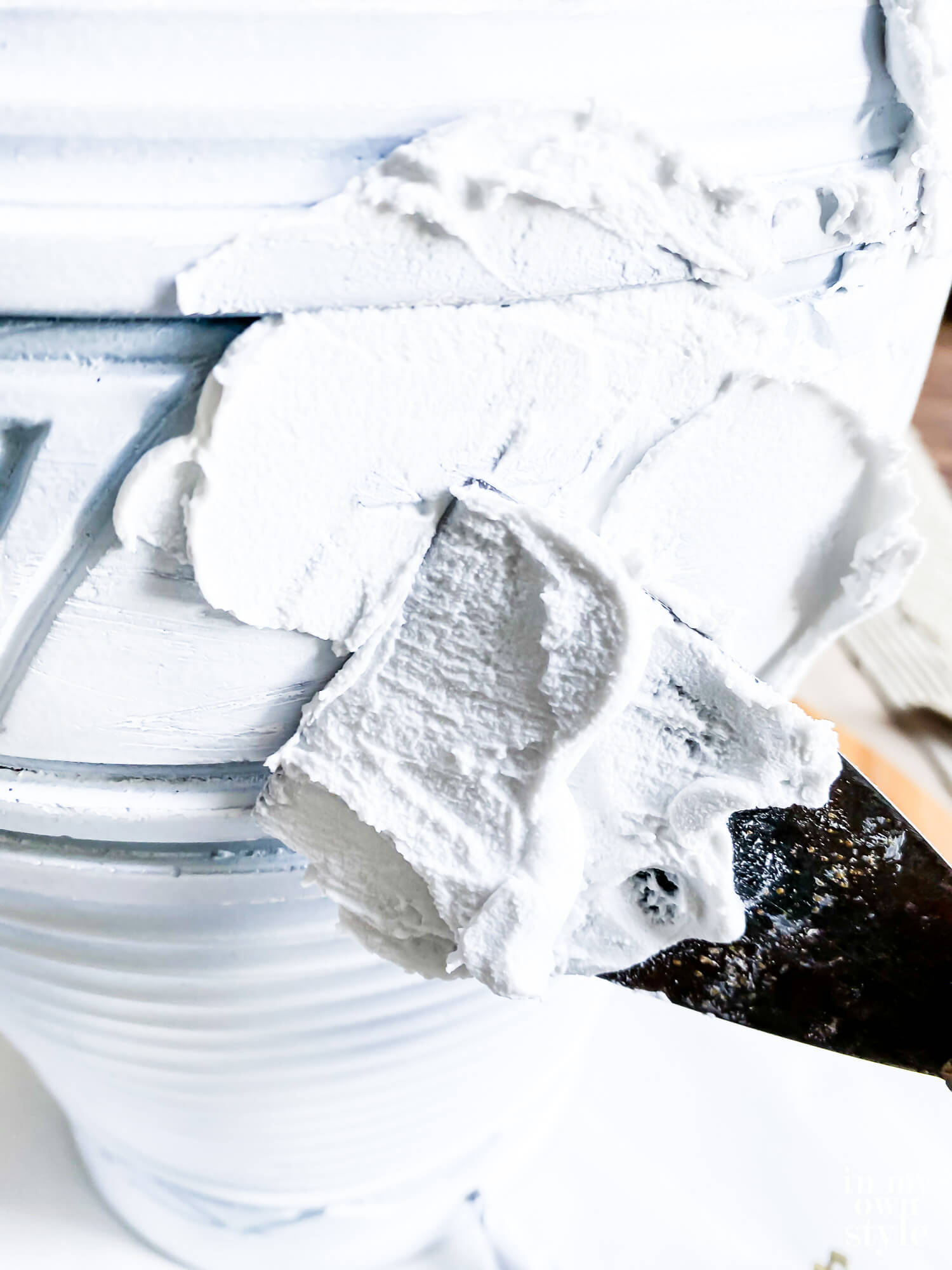 Close up of spreading Spackle over base of thrift store lamp.