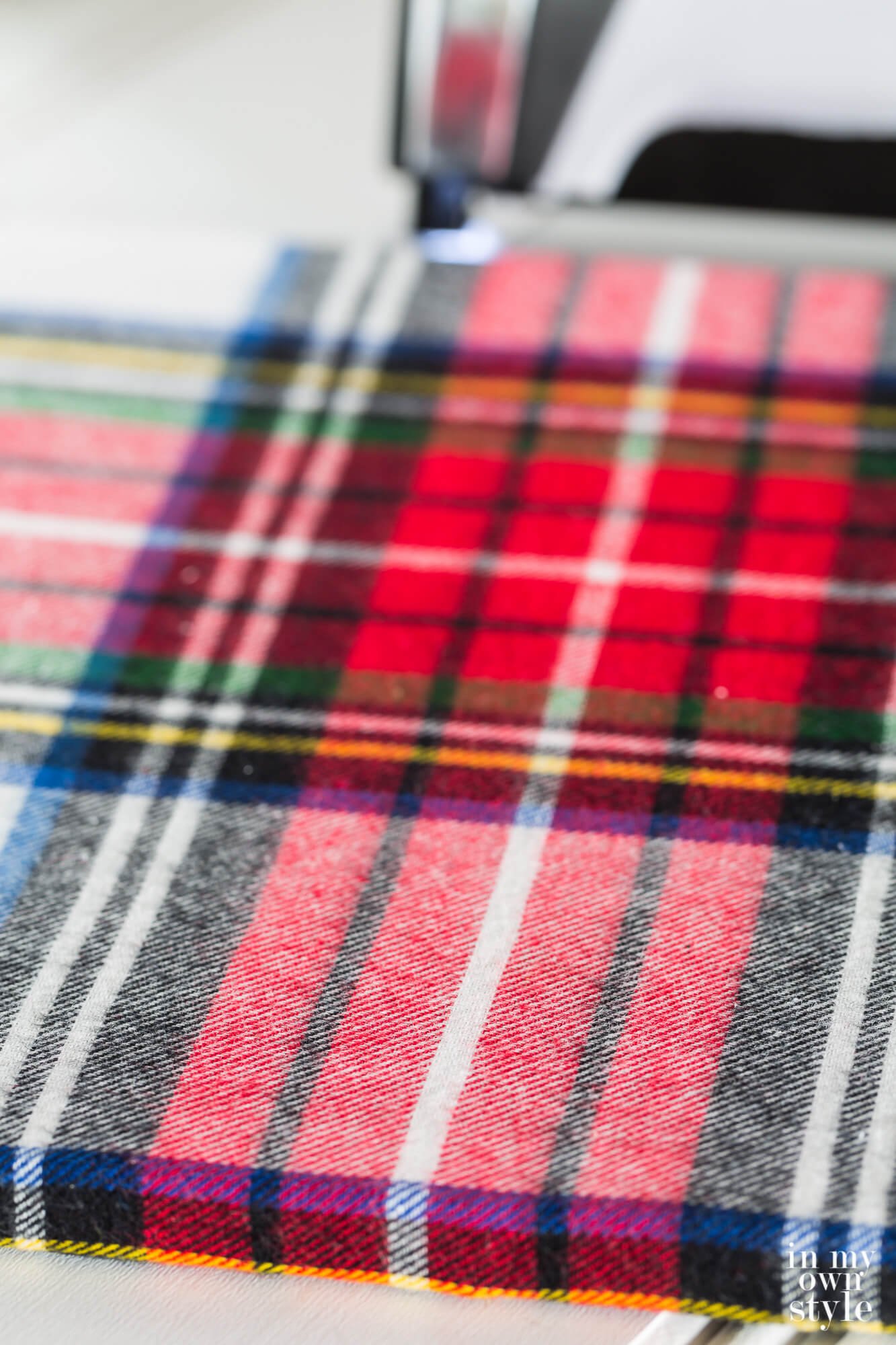 Plaid fabric wrapped around a photo frame that will be made into a wrap around Christmas tree stand.