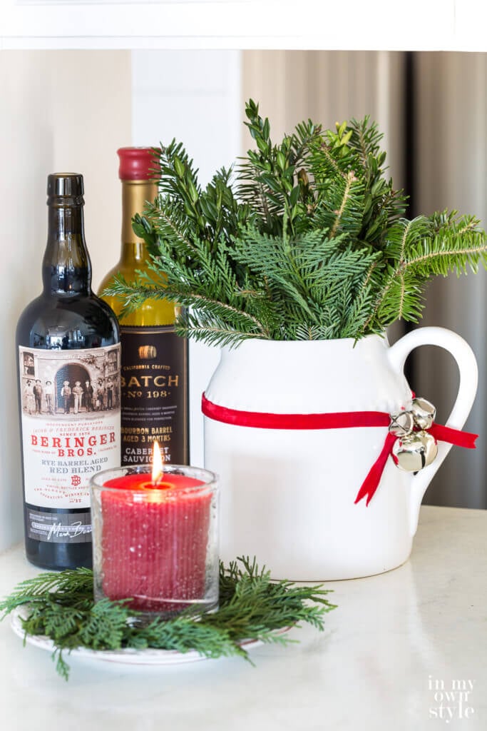 ribbon and jingle bell Christmas decoration on a white pitcher