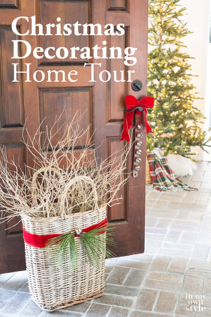 Foyer door open with red ribbon tied sleigh bells and basket. Text overlay says Christmas decorating home tour